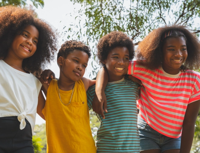 Four children putting their arms on each other's shoulders